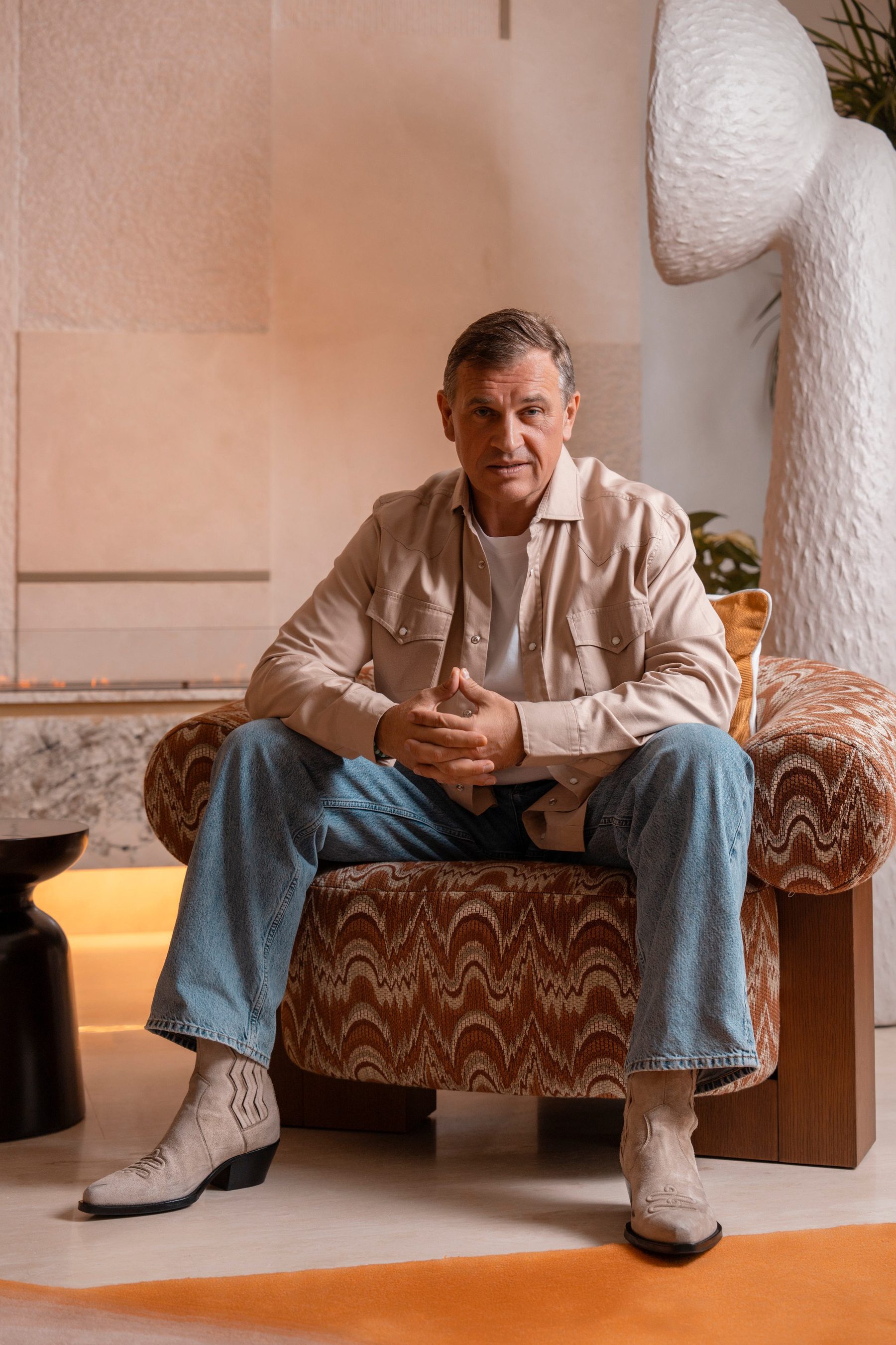 Alex Zagrebelny seated in a warm, sunlit interior